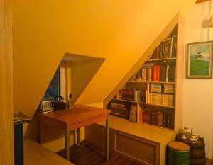 a room with a staircase with a book shelf with books at EcoFit Povlen in Valjevo