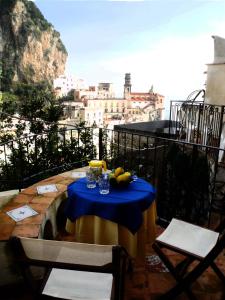 a table with a blue table cloth on a balcony at L'Angolo 7 in Atrani +5 photos