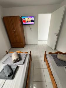 two beds in a room with a tv on the wall at Seaside Apartment in Tsonia in Tsonia +30 photos