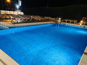 a large blue swimming pool at night at Hotel Susuqui in Sanxenxo