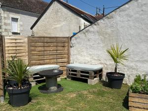 a garden with a bench and potted plants and a fence at Le Perchoir in Saint-Martin-le-Beau