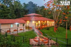 a house with a fire in the yard at The Estate Villa Where Luxury Meets Serenity in Suntikoppa