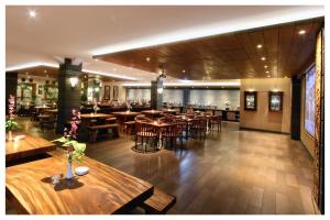 a restaurant with tables and chairs and a bar at Sukajadi Hotel, Convention and Gallery in Bandung