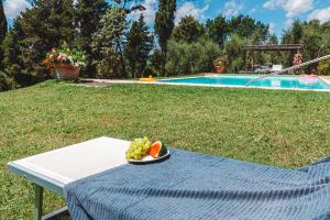 a plate of fruit on a table next to a pool at Fattoria Laviosa in Fauglia