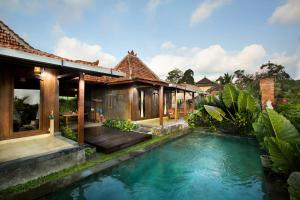 a villa with a pool in front of a house at Naya Ubud in Ubud