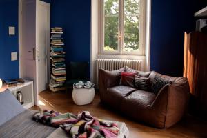 a living room with a leather couch and a window at Villa Willa Walla in Golasecca +21 photos