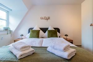 a bedroom with a bed with white sheets and green pillows at ErzGlück Modernes Dachgeschoss-Apartment I nahe Altstadt I Stellplatz & Waschmaschine in Neuwelt
