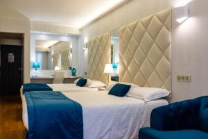 a bedroom with two beds with blue pillows at Hotel Le Fouquet's in Cannes