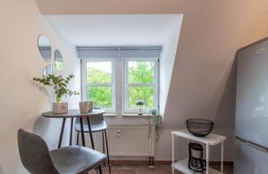 a kitchen with a small table and a window at ErzGlück Modernes Dachgeschoss-Apartment I nahe Altstadt I Stellplatz & Waschmaschine in Neuwelt