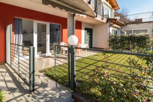 a fence in front of a house at DolceVita Apartment-your vacation on lakes in Carlazzo +18 photos