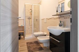 a bathroom with a toilet and a sink at DolceVita Apartment-your vacation on lakes in Carlazzo