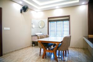 una sala da pranzo con tavolo e sedie di Skyscape Resort a Kaniyāmbetta