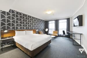 a hotel room with a bed and a desk at KozyGuru | Sydney CBD | Best Location Studio in Sydney