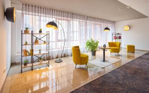 Una sala de estar con sillas amarillas y una mesa. en Trip Inn City Hotel Giessen, en Giessen