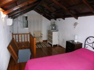 ein Schlafzimmer mit einem rosa Bett und einer Treppe in der Unterkunft Sunset House in Klíma + 17 Fotos