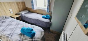 two beds in a small room with blue cushions at Caravan-Blackpool-FamilyFriendly-Activities in Fleetwood +36 photos