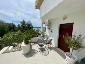 a patio with a table and chairs and potted plants at Sara Brela Apartment in Brela