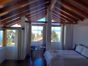 a bedroom with a bed and large windows at Casa de la Luna in Comunidad Yumani
