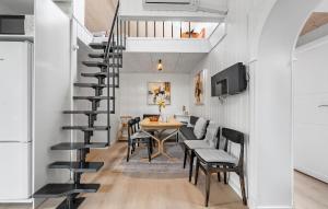 a spiral staircase in a living room with a table and chairs at 4 Bedroom Cozy Home In Rødby in Kramnitse