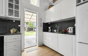 a kitchen with white cabinets and a door to a yard at 4 Bedroom Cozy Home In Rødby in Kramnitse