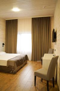 a bedroom with a bed and a desk and a chair at Sunrise Hotel in Kyiv