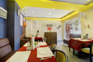 a dining room with tables and chairs in a restaurant at Hotel O India Gate in Chennai