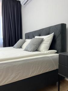 ein großes Bett mit weißen Laken und Kissen darauf in der Unterkunft Lago Mare Apartment in Pomorie