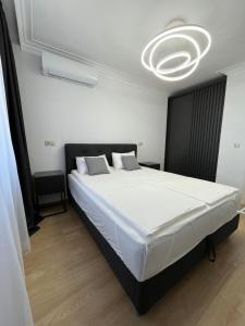 ein Schlafzimmer mit einem großen weißen Bett und einem Kronleuchter in der Unterkunft Lago Mare Apartment in Pomorie