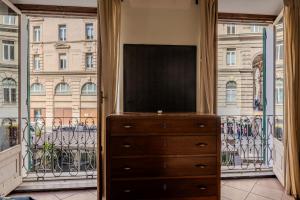 a dresser with a television in front of a window at lovingenoa Natural - Light in Genoa