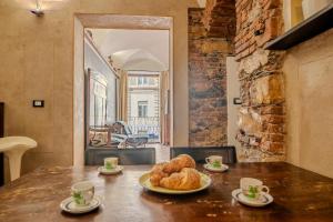 a table with a plate of croissants on it at lovingenoa Natural - Light in Genoa