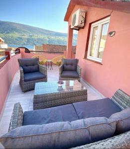 a patio with a couch and chairs on a house at Villa Đuričić 200m od mora in Đenovići