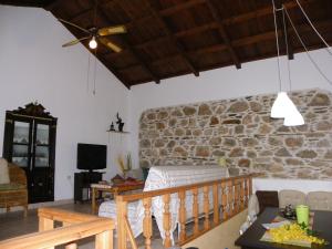 ein Wohnzimmer mit einer Steinwand in der Unterkunft Sunset House in Klíma