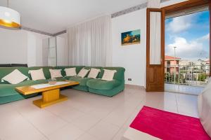 a living room with a green couch and a table at Vista Mare Lido Avola in Avola