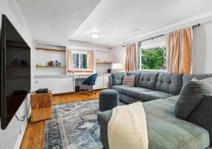 a living room with a couch and a tv at Large Remodeled 4 Bed 3 Bath Secluded With Hot Tub in Akron
