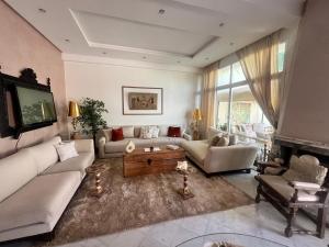 un salon avec deux canapés et une télévision dans l'établissement Maison d'hôte Darkom Kech, à Marrakech