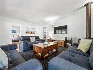 Una sala de estar con dos sofás y una mesa. en Margs In Mandurah- Classic Family Holiday Abode!, en Dawesville 24 fotos más