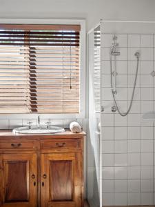 a bathroom with a sink and a shower at Margs In Mandurah- Classic Family Holiday Abode! in Dawesville +24 photos