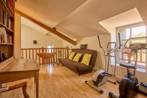 una sala con palestra, sedia e tapis roulant di CAPE - maison avec piscine et jacuzzi a Thénac