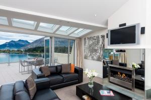 a living room with a couch and a fireplace at Oaks Queenstown Club Suites in Queenstown