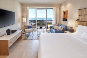 a hotel room with a bed and a living room at The Westin Resort, Costa Navarino in Romanu