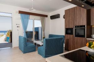 a living room with blue chairs and a kitchen at Laftiras Sea View Home in Archangelos +9 photos