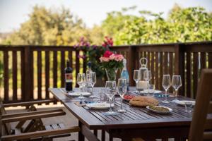 a wooden table with wine glasses and bread and flowers at Laftiras Sea View Home in Archangelos