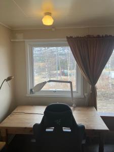 a room with a wooden table and a window at Cheap Apartment near airport with included parking, washer and dryer Always Ready Finhaugveien 5 in Evenesmarkja