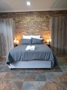 a bedroom with a large bed with two white shoes at Mitchell Manor in Vryheid