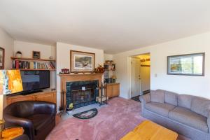 a living room with a couch and a fireplace at 11D - Spacious & Family-Friendly Getaway in North Creek