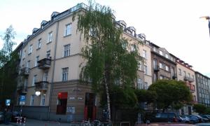 un edificio con un árbol delante en Top Apartments - Dunin Wąsowicza, en Cracovia