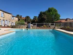 a swimming pool with blue water in a yard at La Frouardière, 3 gîtes de charme in Antigny