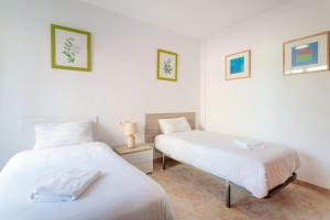 dwa łóżka w pokoju z białymi ścianami w obiekcie Montefaro Spacious Townhouse - Beach & pool w mieście Santa Pola +37 zdjęć
