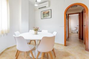 biała jadalnia z białym stołem i białymi krzesłami w obiekcie Montefaro Spacious Townhouse - Beach & pool w mieście Santa Pola
