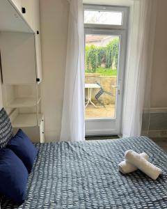 a bedroom with a bed and a window with a table at Nid Bleu - Central - Wifi - Équipé in Dax